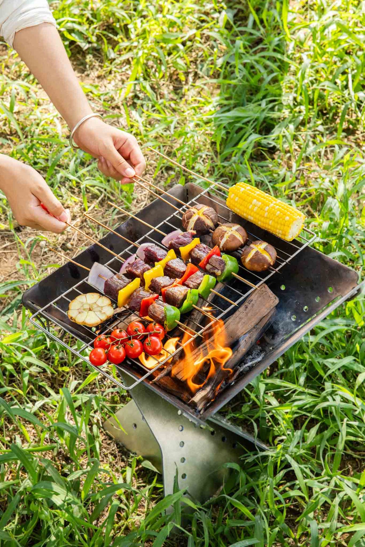 Keith Titanium Ti2211 grill mesh cooking skewers and vegetables over a charcoal grill