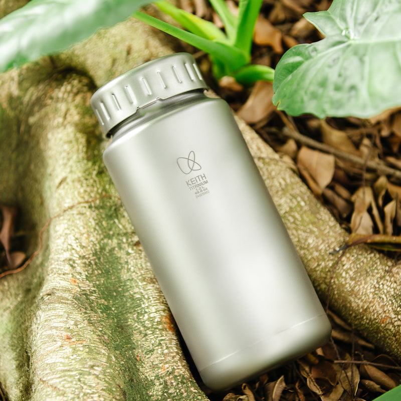 Keith Titanium Ti3036 titanium bottle resting on a tree root outdoors