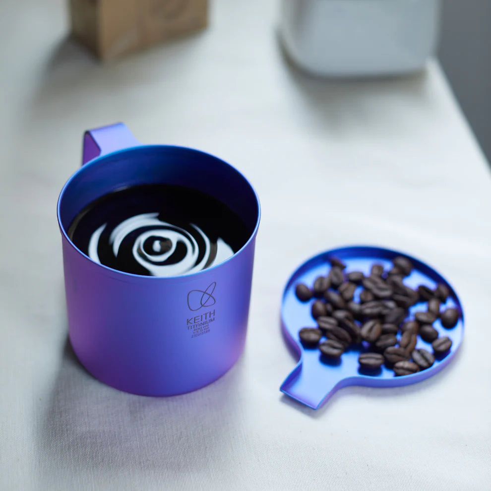 コーヒー豆の横でコーヒーを入れたKEITH Titaniumトワイライトパープルカラーカップ