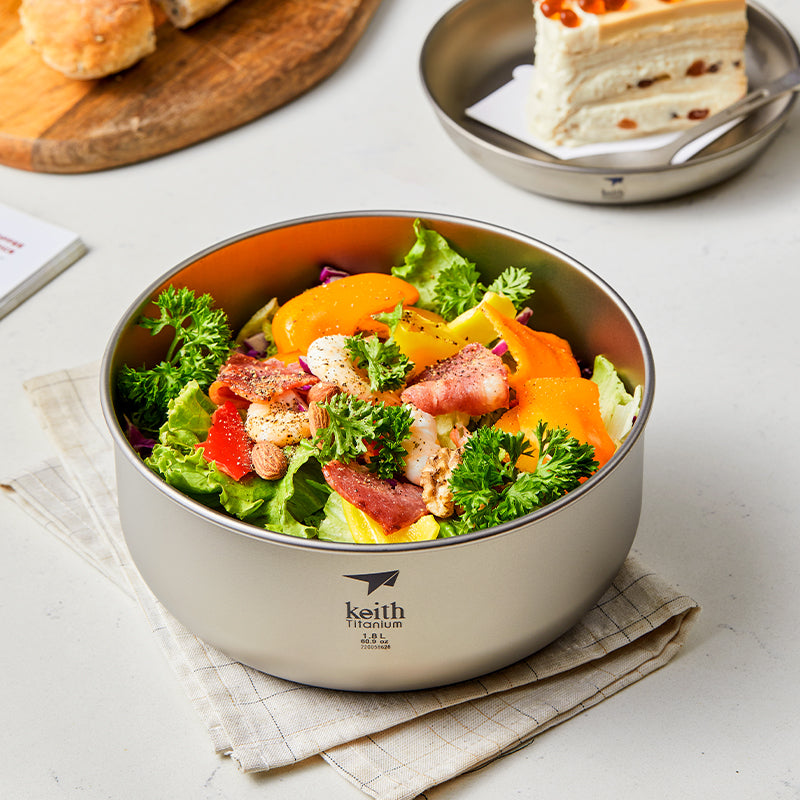 Keith Titanium Ti8701 ultralight salad bowl filled with salad on a tabletop beside dessert