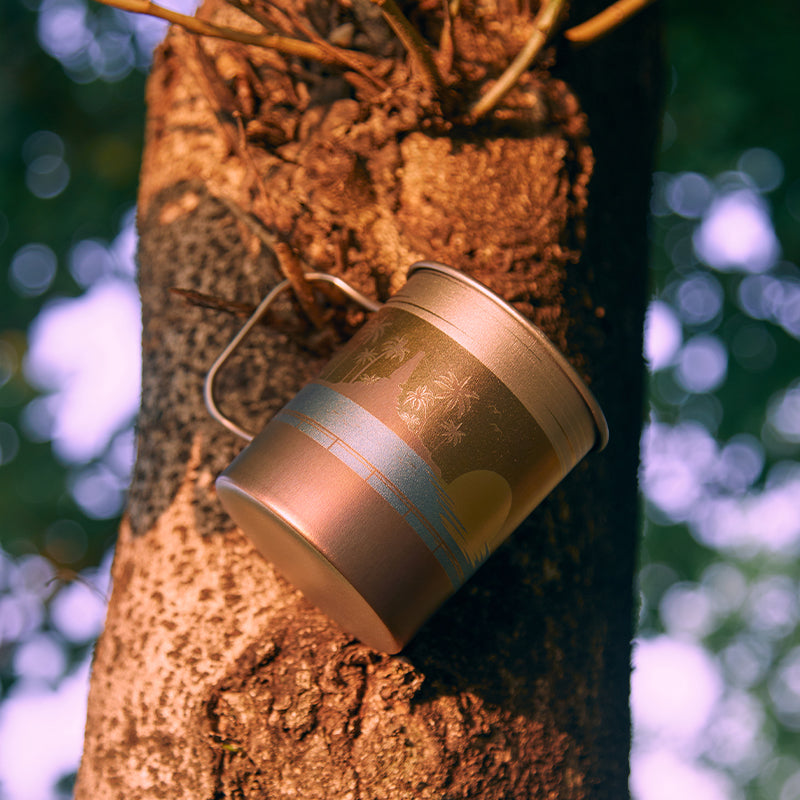 屋外の木の幹に掛けられたKEITH Titanium Ti3532 Artisan Sunset Glowマグ