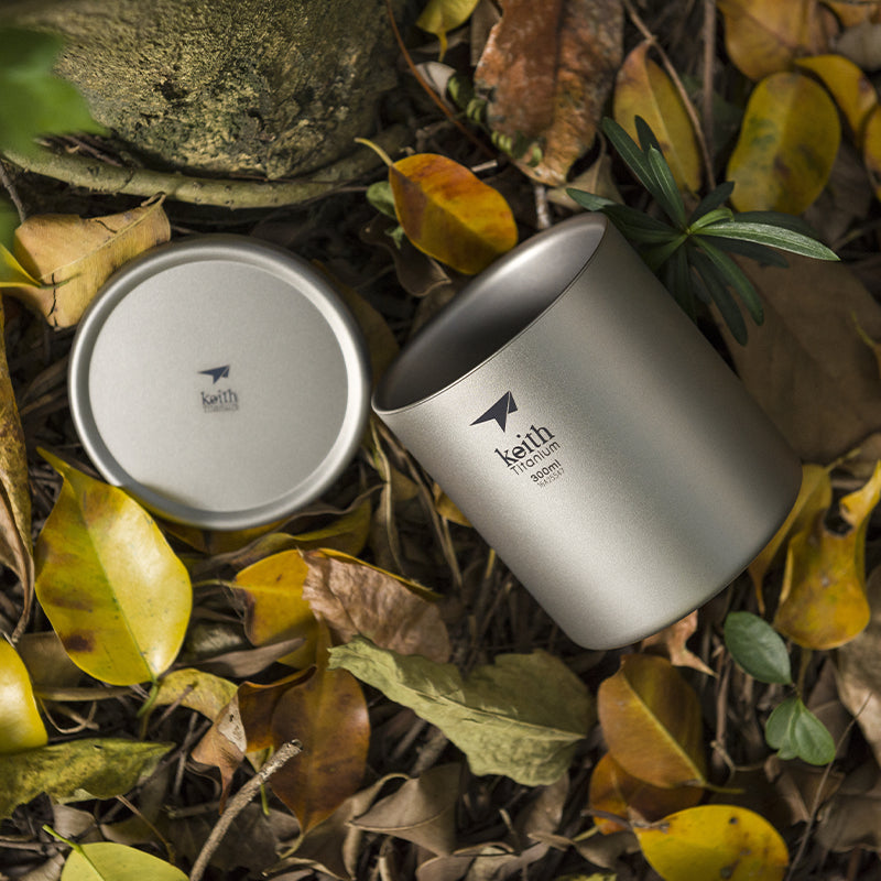 Keith Titanium 300 ml mug and lid resting among dry leaves outdoors