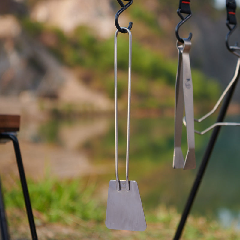 Keith Titanium Ti2208 ultralight spatula hanging from a camp hook outdoors