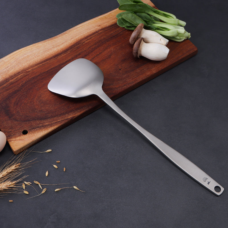 Keith Titanium Ti8704 spatula resting on a cutting board beside vegetables and mushrooms