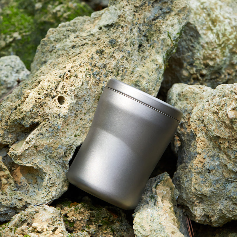 Keith Titanium Ti3312 insulated mug resting among rocks outdoors