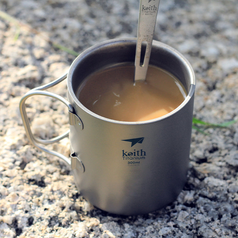 Close-up of the Keith Titanium Ti3353 mug with a drink and stirring utensil outdoors