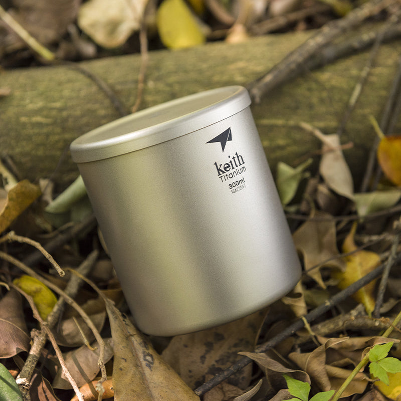 Keith Titanium 300 ml double-wall mug standing among dry leaves outdoors