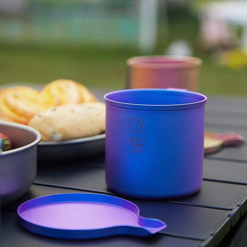 Keith Titanium marine blue radiant spectrum cup on a camp table beside pastries