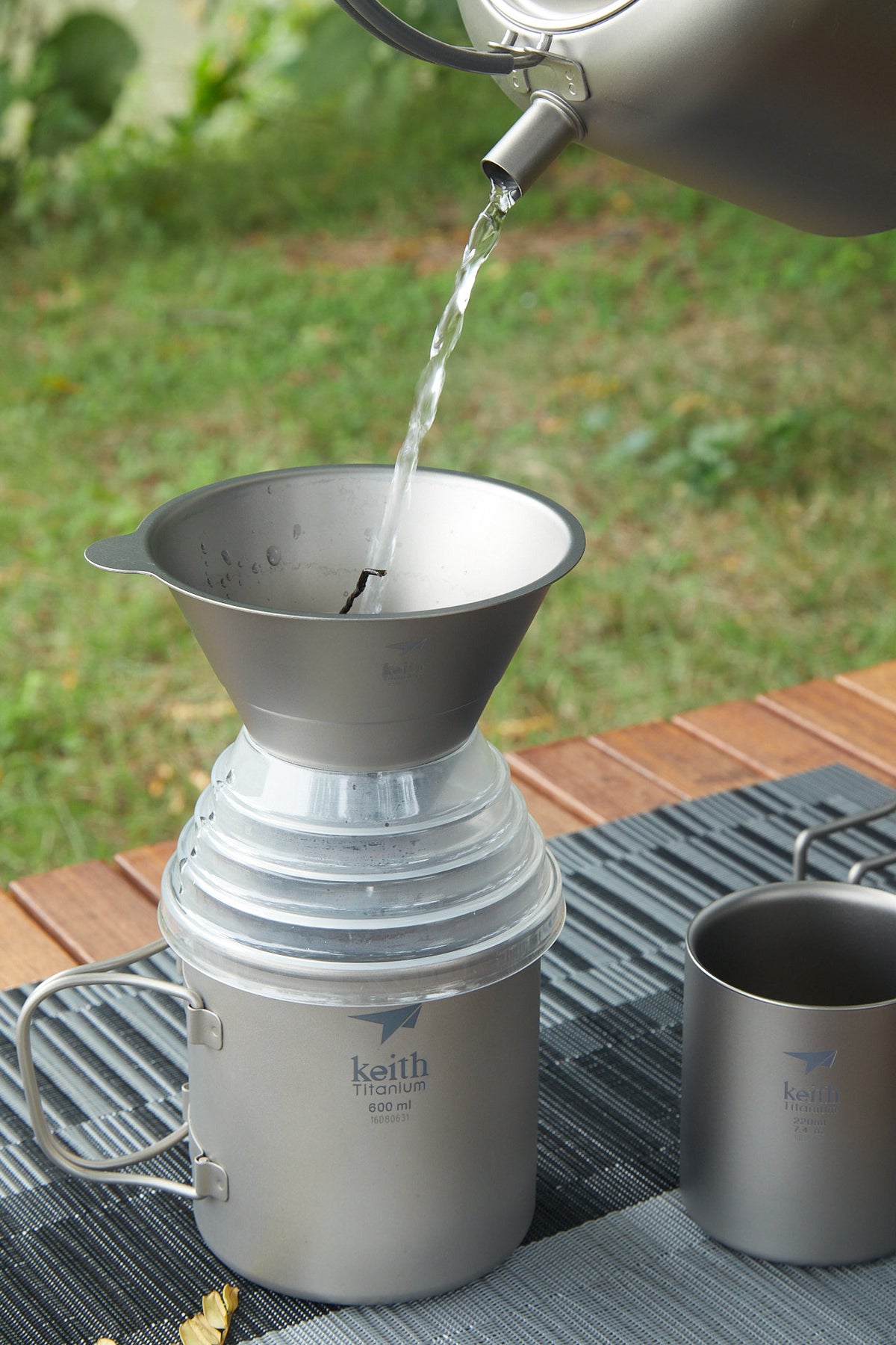 屋外でKEITH Titanium Ti3661コーヒーファンネルに湯を注いでいる様子