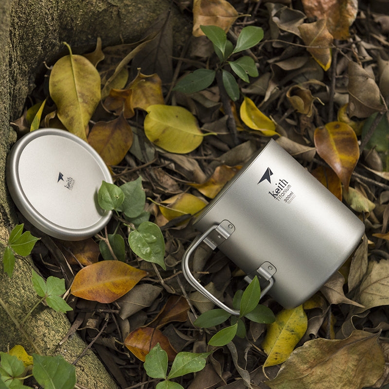 Keith Titanium Ti3353 mug and lid resting among dry leaves outdoors