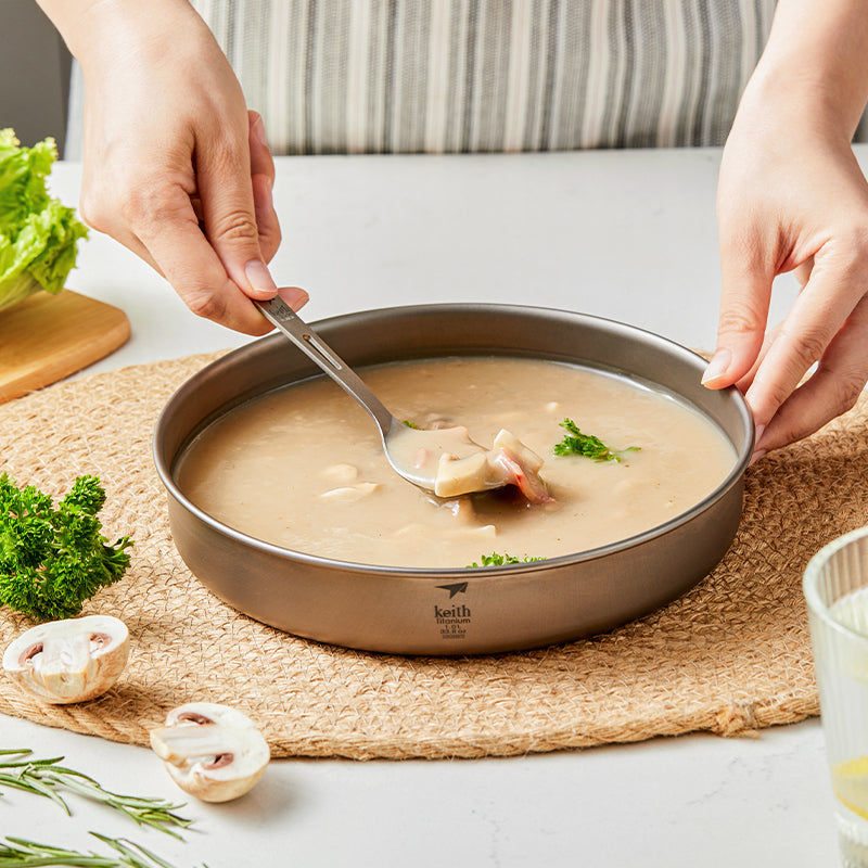Keith Titanium Ti8702 ultralight plate holding creamy soup while a spoon scoops a bite