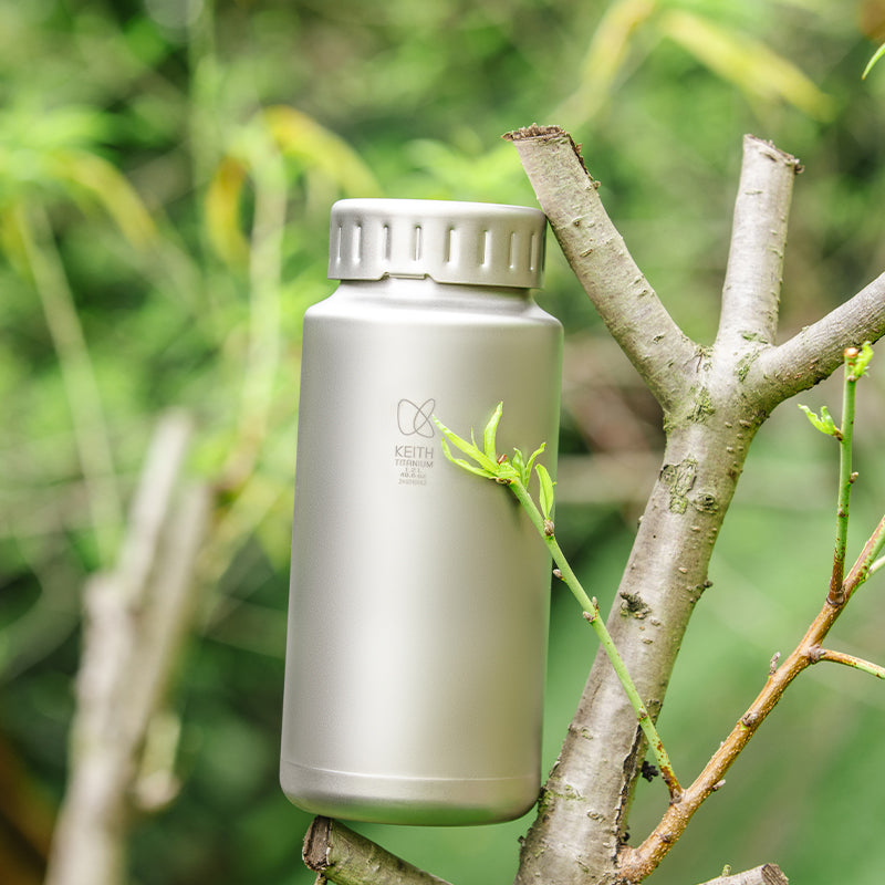Keith Titanium Ti3035 bayonet-cap bottle standing outdoors beside a branch