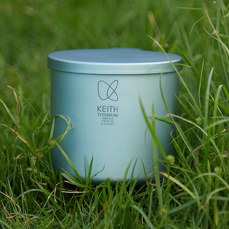 Close-up of the Keith Titanium lake cyan radiant spectrum cup in tall grass