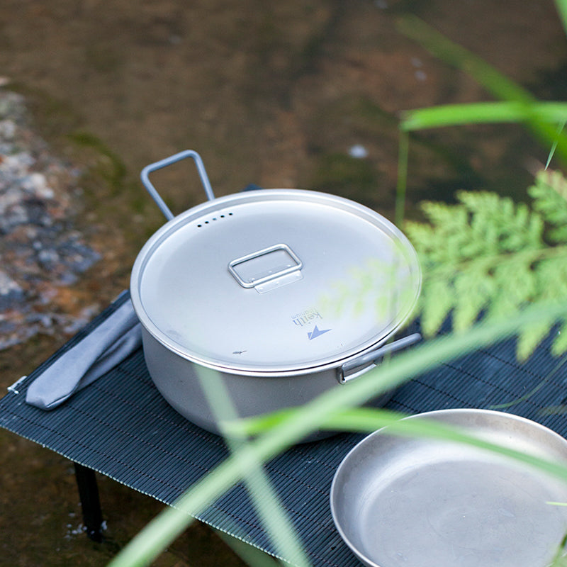 Keith Titanium Ti6015 1.8 L pot with lid on a camp table beside a stream