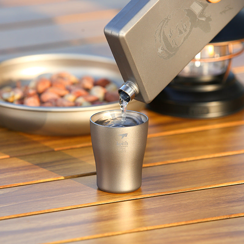Baijiu being poured into a Keith Titanium Ti9304 shot glass on a wooden table
