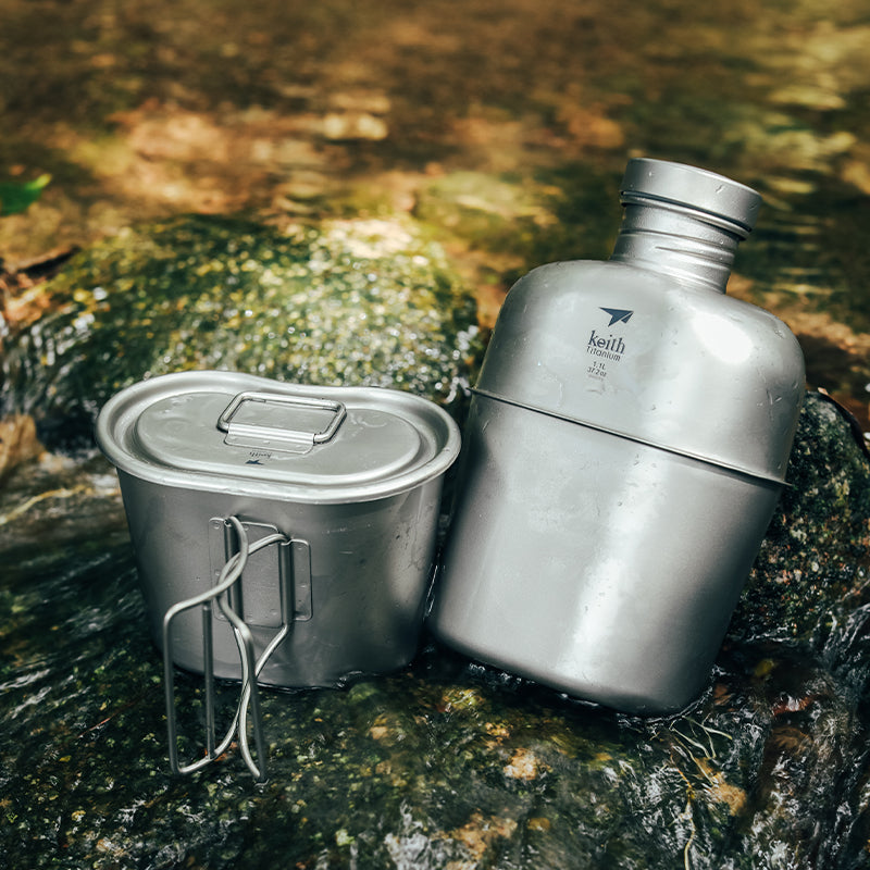 Keith Titanium Ti3060 titanium canteen mess kit resting on wet rocks beside a stream