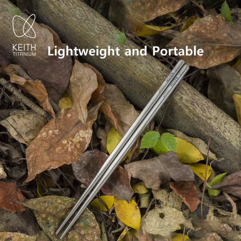 Keith Titanium Ti5622 titanium chopsticks resting on dry leaves beside a branch outdoors