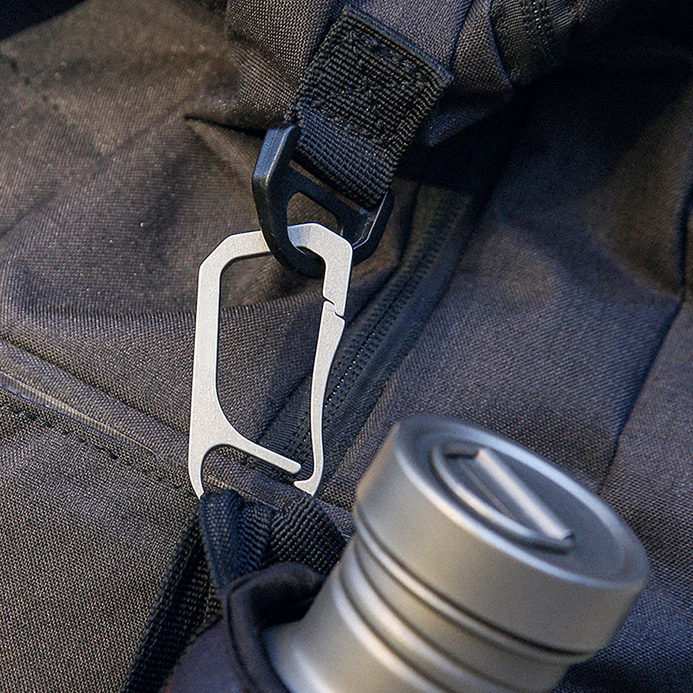 Keith Titanium Ti1155 carabiner clipped to a backpack strap beside a bottle