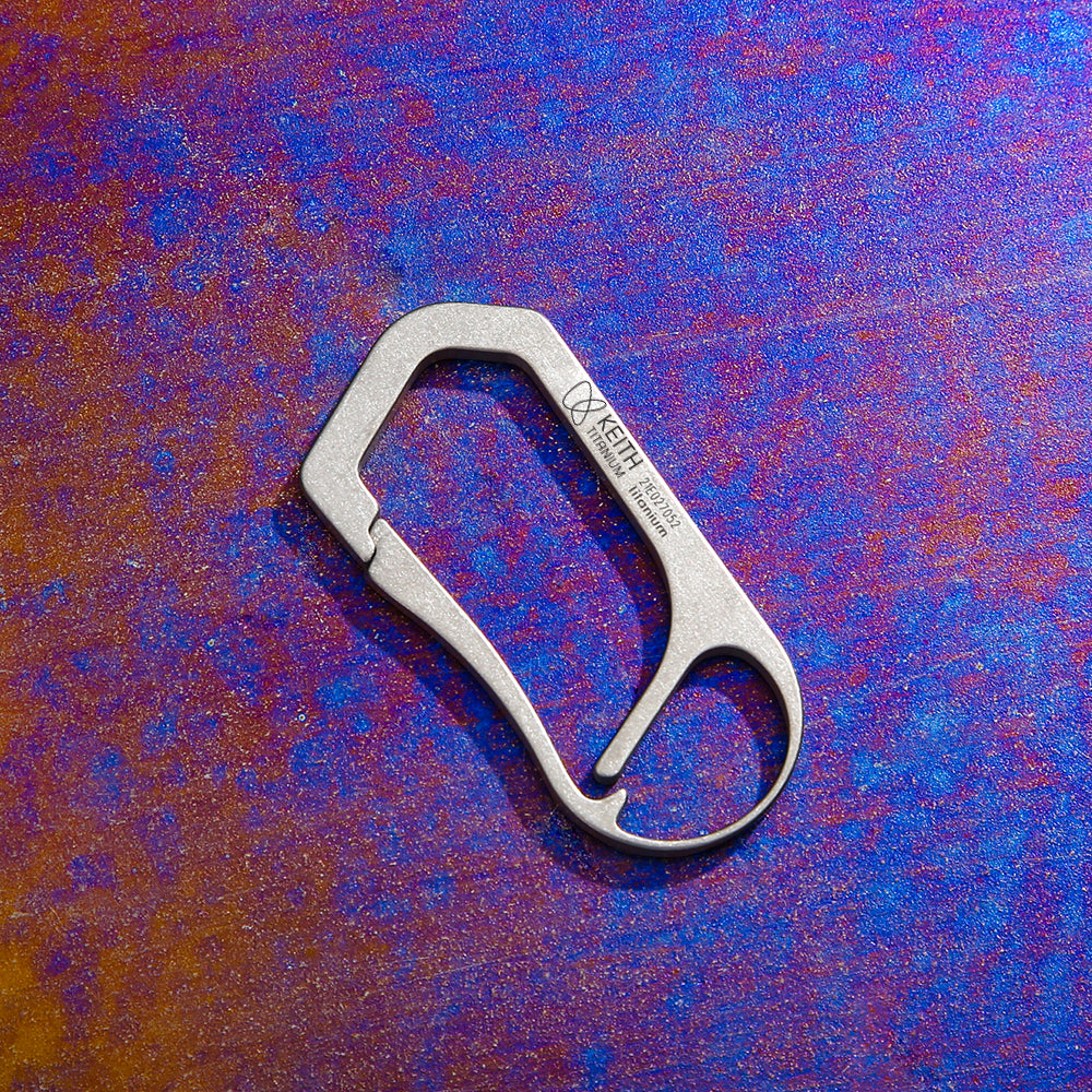 Keith Titanium Ti1155 carabiner on a purple-blue textured background