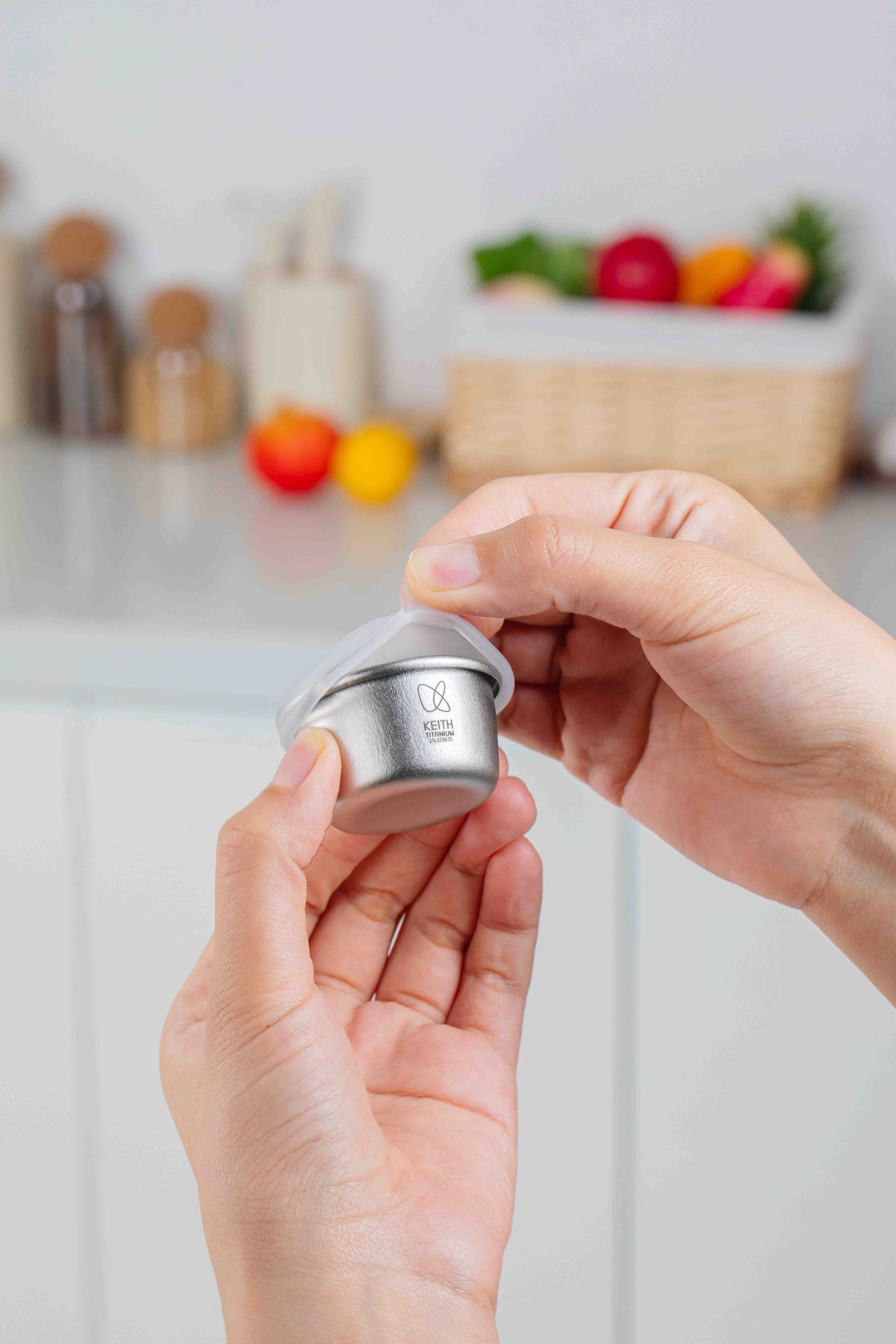 Hands removing the translucent lid from a Keith Titanium Ti1161 mini container