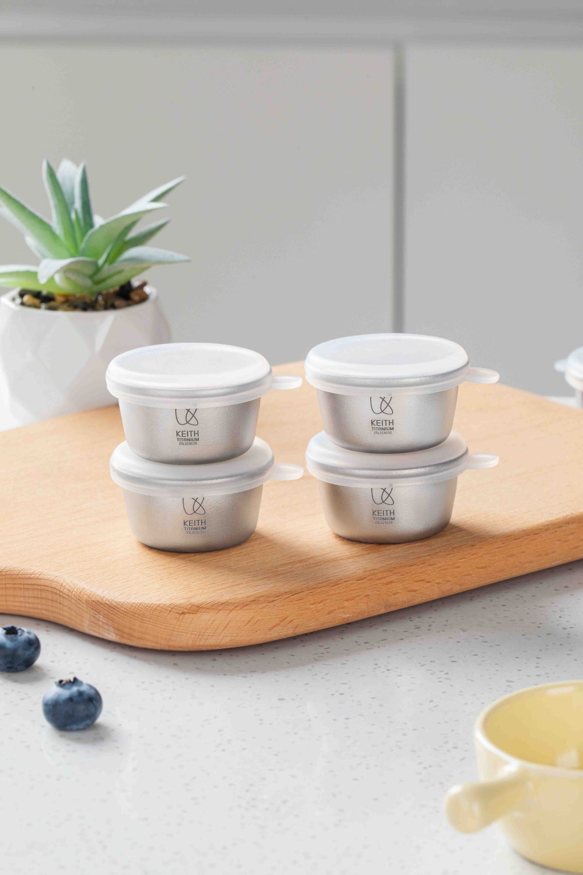 Four Keith Titanium Ti1161 mini containers arranged in pairs on a wooden board