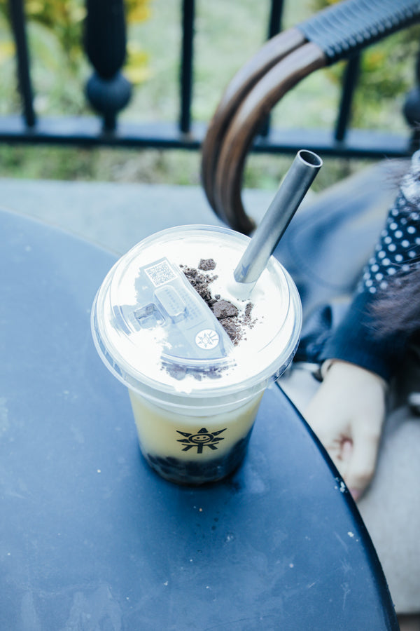 Drink cup with the Keith Titanium Ti3702 straw inserted through the lid on a table