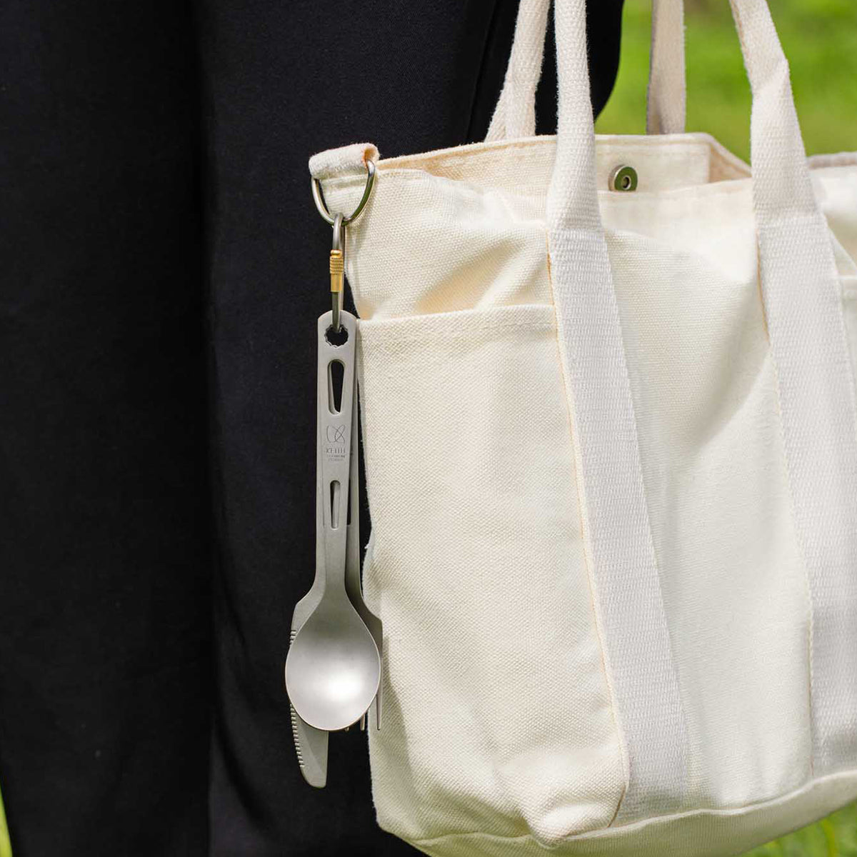 Keith Titanium Ti1150 carabiner clipped to a canvas tote bag with a titanium utensil attached