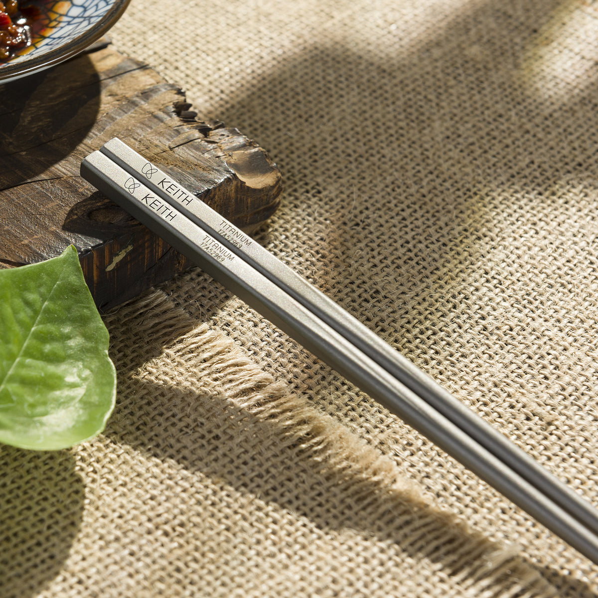 Keith Titanium Ti5633 titanium chopsticks placed on a woven table mat