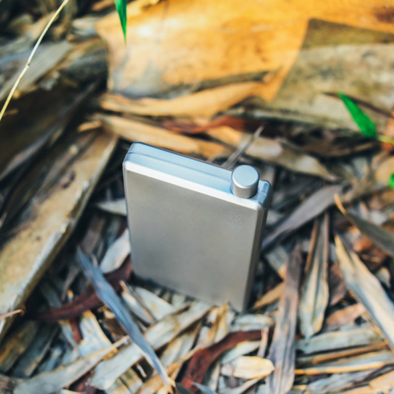 Angled top view of the Keith Titanium titanium pocket flask on dry leaves