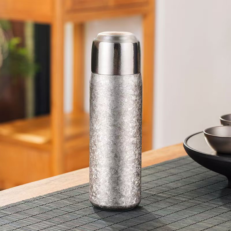 KEITH Ti3107 silver titanium vacuum-insulated bottle with textured finish on a tea table